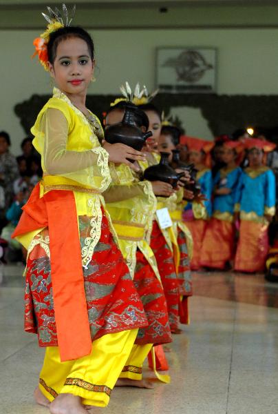 Pupils with folk dress perform traditional dance in Jakarta, capital of Indonesia, April 11, 2010.