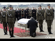 The casket bearing the remains of President Lech Kaczynski is met by his twin brother, former Prime Minister Jaroslaw Kaczynski, at the airport in Warsaw, Poland, on Sunday, April 11, 2010. [People.com]