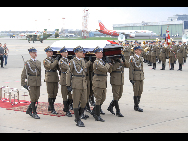 The casket bearing the remains of President Lech Kaczynski arrives at the airport in Warsaw, Poland, on Sunday, April 11, 2010. Kaczynski and dozens of top Polish political and military leaders died in a plane crash in western Russia on Saturday. [Xinhua]