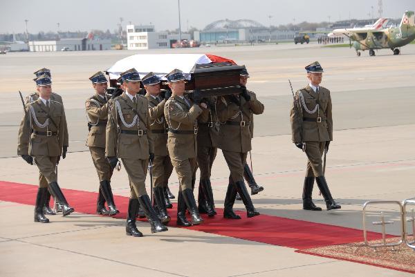 Soldiers escort the coffin of Polish President Lech Kaczynski at the airport in Warsaw, capital of Poland, April 11, 2010. The body of Polish President Lech Kaczynski who died in a plane crash in Russia on Saturday has returned to Poland. The plane carrying the flag-draped coffin landed in Warsaw on Sunday. [Ma Shijun/Xinhua] 