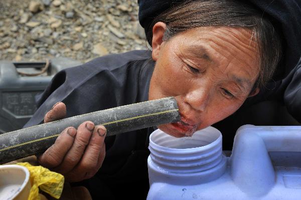 A villager drinks water at Jiaolong Village in Wangmo County, southwest China&apos;s Guizhou Province, April 10, 2010. As severe drought has ravaged China&apos;s southwest region since last October, leading to serious drinking water shortage of local human beings and livestocks, the local police managed to build kilometres long water pipe to help solve the problem. [Xinhua] 