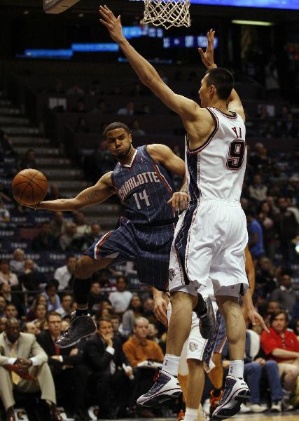 Charlotte Bobcats' D.J. Augustin (L) passes against New Jersey Nets' Yi Jianlian in the second half of their NBA basketball game in East Rutherford, New Jersey April 12, 2010. This is the Nets' last game at the Izod Center after playing for 29 seasons at this arena. Nets lost 95-105.(Xinhua/Reuters Photo)