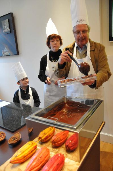 Tourists try to make chocolates after a short term training in Brussels, Belgium on March 27, 2010. (Xinhua/Wang Xiaojun)