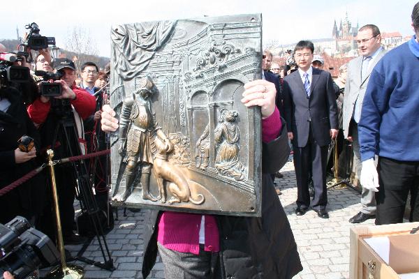 A worker shows a bronze plaque which has been polished to shine by many people who had touched it over centuries for luck, on Charles Bridge in Prague, capital of the Czech Republic, April 12, 2010. The bronze plaque will be delivered to the Shanghai World Expo and exhibited in the Czech Pavilion. (Xinhua/Sun Xiyou)