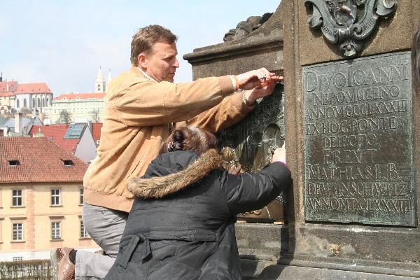 Workers removes a bronze plaque which has been polished to shine by many people who had touched it over centuries for luck, on Charles Bridge in Prague, capital of the Czech Republic, April 12, 2010. (Xinhua/Sun Xiyou) 