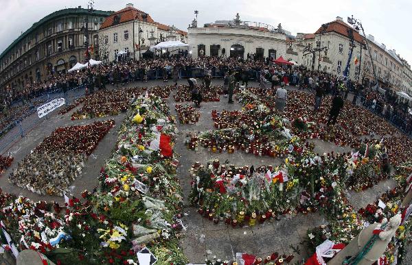 Candles and flowers are seen in a square near the Presidential Palace in Warsaw April 13, 2010. Officials said a memorial service for all 96 victims of the plane crash that killed President Lech Kaczynski, his wife and dozens of high-ranking officials would be held on Saturday and that a state funeral for Kaczynski and his wife could take place either on the same day or on Sunday. [Xinhua]