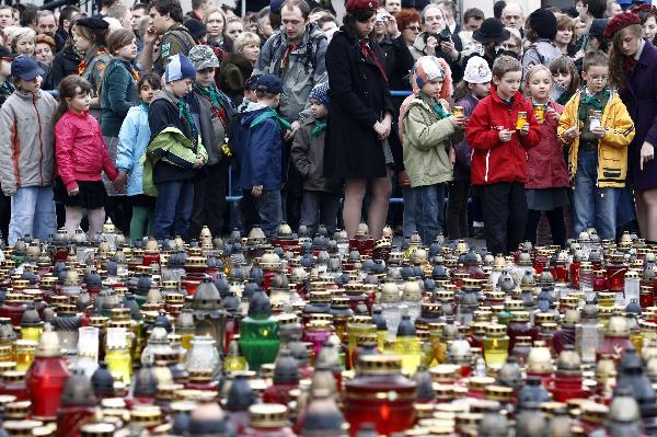 Children hold candles in a square near the Presidential Palace in Warsaw April 13, 2010. Officials said a memorial service for all 96 victims of the plane crash that killed President Lech Kaczynski, his wife and dozens of high-ranking officials would be held on Saturday and that a state funeral for Kaczynski and his wife could take place either on the same day or on Sunday.[Xinhua]