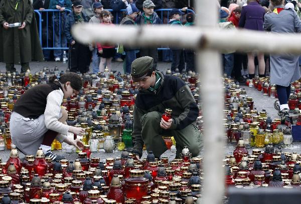 People place candles on a square near the Presidential Palace in Warsaw April 13, 2010. Officials said a memorial service for all 96 victims of the plane crash that killed President Lech Kaczynski, his wife and dozens of high-ranking officials would be held on Saturday and that a state funeral for Kaczynski and his wife could take place either on the same day or on Sunday.[Xinhua]