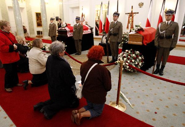 People pay their respects in front of the coffins of the late Polish President Lech Kaczynski and his wife Maria at the President&apos;s Palace in Warsaw April 13, 2010. Kaczynski and his wife Maria will be buried in the cathedral crypt at Wawel Royal Castle in Poland&apos;s southern city of Krakow on Sunday, a Polish cardinal said on Tuesday. [Xinhua]