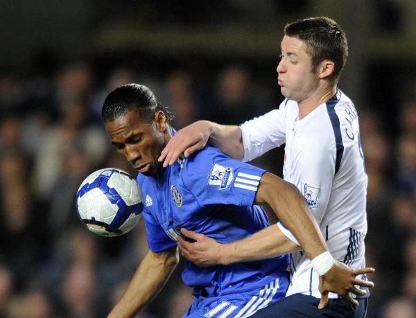 Chelsea's Didier Drogba (L) and Bolton's Gary Cahill fight for the ball during their English Premier League soccer match at Stamford Bridge in London April 13, 2010. Chelsea won 1-0.(Xinhua/Reuters Photo)