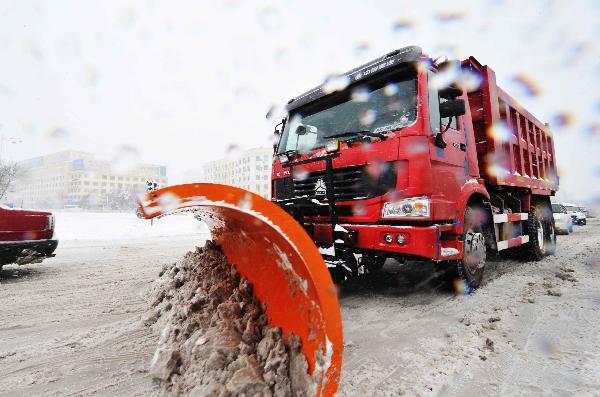 A snow clearer clears snow in the street in Harbin, northeast China&apos;s Heilongjiang Province, April 13, 2010. Meteorological authorities in Harbin issued snowstorm red alert early Tuesday morning, saying the snow will continue with precipitation of 15 millimeters over six hours.[Xinhua]