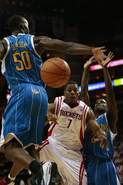 Houston Rockets' Kyle Lowry (C) passes the ball during the NBA basketball game against New Orleans Hornets in Houston, the United States, April 14, 2010. Hornets won by 123-115. This is the last game of the regular season for the Rockets. (Xinhua)