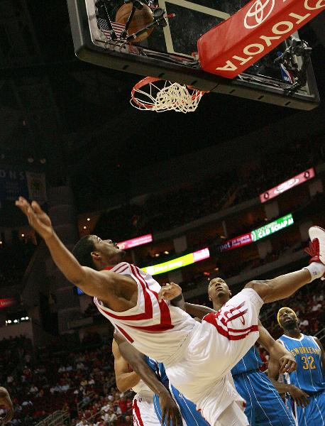 Houston Rockets' Trevor Ariza (front) falls after shooting against New Orleans Hornets during the NBA basketball game in Houston, the United States, April 14, 2010. Hornets won by 123-115. This is the last game of the regular season for the Rockets. (Xinhua)