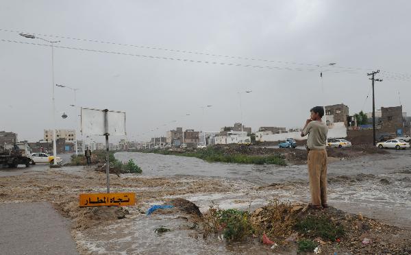 A man looks at the flood cutting a street in Sanaa, capital of Yemen, April 14, 2010. A heavy rain hit the low rainfall Sanaa on Wednesday, causing flooding on the streets.[Xinhua]