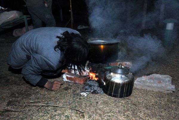 A survivor prepares meal after a quake in Yushu County, northwest China's Qinghai Province, April 14, 2010. About 400 people have died and 10,000 others were injured after a 7.1-magnitude earthquake hit Yushu early on Wednesday. 