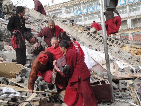 Local people succor the injured persons from the debris of crumbled houses shortly after an earthquake jolted at 7:49 a.m., at Gyegu Town, of Yushu, a Tibetan autonomous prefecture in western Qinghai Province of northwest China, April 14, 2010
