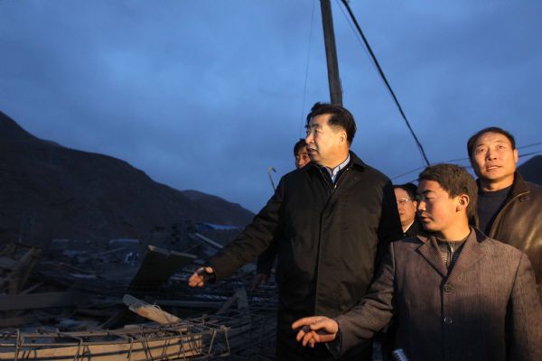 Chinese Vice Premier Hui Liangyu (3rd R Front) looks at the ruins of collapsed houses in the quake-hit area in Yushu County, northwest China's Qinghai Province, April 14, 2010. Hui rushed to the quake-hit region to direct the rescue work on Wednesday.