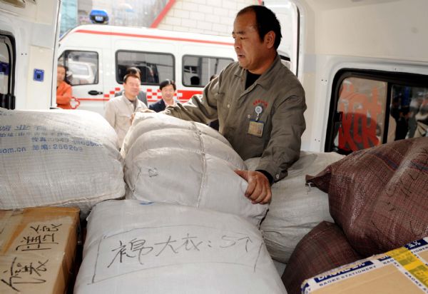 People load the materials heading for the quake area in Urumqi, capital of northwest China's Xinjiang Uygur Autonomous Region, April 15, 2010. 
