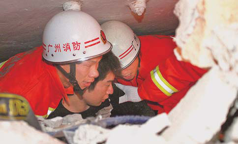 Rescuers pull Zou Jiang, owner of a photo studio, from a collapsed building in Gyegu, Yushu, on Thursday. [China Daily]  