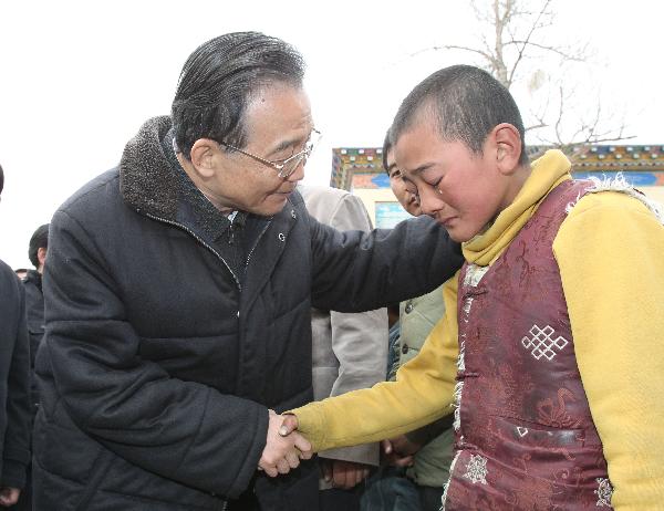 Chinese Premier Wen Jiabao (L) consoles a boy as he visits orphans in Yushu County of northwest China's Qinghai Province, April 16, 2010. Premier Wen continued his visit in quake-hit Yushu County on Friday, and visited quake-devastated schools, orphanages, monasteries and camps for quake-displaced people. 