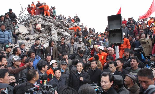 Chinese Premier Wen Jiabao (C Bottom) talks to people in Yushu County of northwest China's Qinghai Province, April 15, 2010. Premier Wen continued his visit in quake-hit Yushu County on April 16, and visited quake-devastated schools, orphanages, monasteries and camps for quake-displaced people.