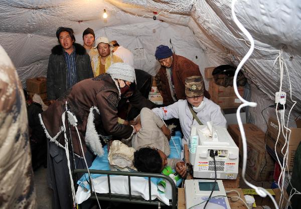 A military doctor dose type-B ultrasonic check for an injured at a tent hospital in Gyegu Town of earthquake hit Yushu County of northwest China's Qinghai Province,April 16,2010.Dozens of medical team have rushed to Yushu from all over China since the 7.1-magnitude quake struck here early Wednesday