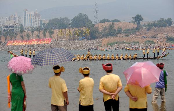 Some locals of Dai ethnic group watch dragon boat race in Jinghong City in Dai Autonomous Prefecture of Xishuangbanna, Yunnan Province, April 13, 2010. 
