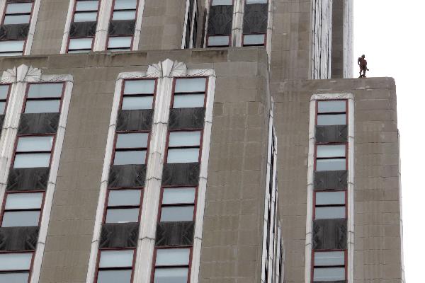 A life-size sculpture by British artist Antony Gormley is placed on the Empire State Building in New York, the United States, April 16, 2010. Thirty one life-size sculptures by British artist Antony Gormley are installed on sidewalks and rooftops of buildings near the Empire State Building as an art display called 'Event Horizon'.