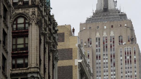 A life-size sculpture by British artist Antony Gormley is placed on the rooftop of a building near the Empire State Building in New York, the United States, April 16, 2010. Thirty one life-size sculptures by British artist Antony Gormley are installed on sidewalks and rooftops of buildings near the Empire State Building as an art display called 'Event Horizon'. 