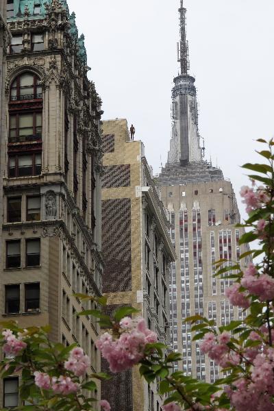 A life-size sculpture by British artist Antony Gormley is placed on the rooftop of a building near the Empire State Building in New York, the United States, April 16, 2010. Thirty one life-size sculptures by British artist Antony Gormley are installed on sidewalks and rooftops of buildings near the Empire State Building as an art display called 'Event Horizon'. 