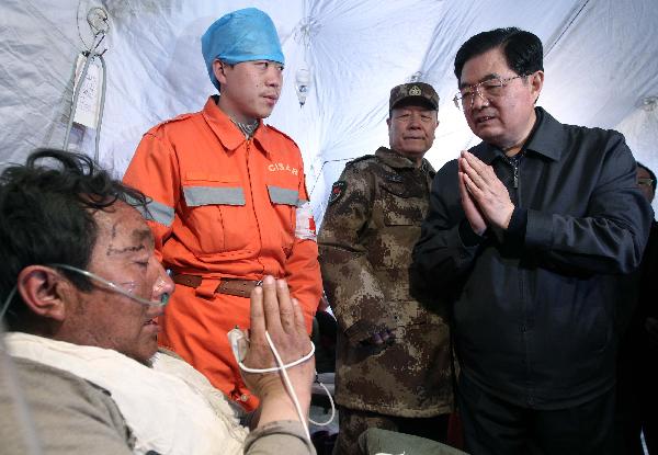 Chinese President Hu Jintao (R) consoles those injured in the quake receiving treatment at the stadium in Yushu County of northwest China's Qinghai Province, April 18, 2010. President Hu arrived in quake-hit Yushu Sunday morning to direct relief work. [Xinhua]