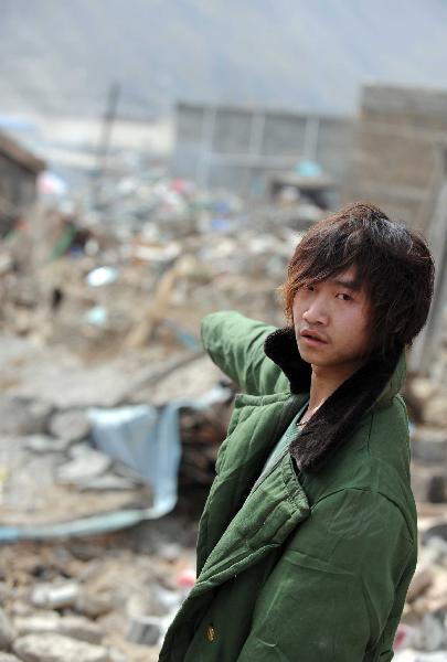 Yang Yang, a 23-year-old young man who saved seven lives from the quake debris, shows the house that witnessed his heroism in Gyegu, northwest China's Qinghai Province, April 17, 2010. On feeling the earthquake on April 14, Yang yang rushed out of his working place and found neighbouring residential buildings crumbled to ruins. With bare hands, Yang digged out seven buried people in all.