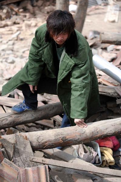 Yang Yang, a 23-year-old young man who saved seven lives from the quake debris, shows the house that witnessed his heroism in Gyegu, northwest China's Qinghai Province, April 17, 2010. On feeling the earthquake on April 14, Yang yang rushed out of his working place and found neighbouring residential buildings crumbled to ruins. With bare hands, Yang digged out seven buried people in all.