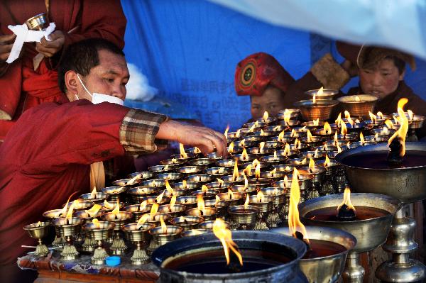 Monks light butter lamps to pray for the quake victims in a tent in quake-hit Gyegu Town of Yushu County, northwest China's Qinghai Province, April 17, 2010.