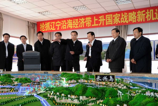 Chinese Vice Premier Li Keqiang (4th R) listens to the introduction of the comprehensive plan of the construction of Lingang Industrial Park at Changxingdao in Dalian, northeast China's Liaoning Province, April 15, 2010. Li made an inspection tour in Liaoning from April 14 to 17. [Li Tao/Xinhua]