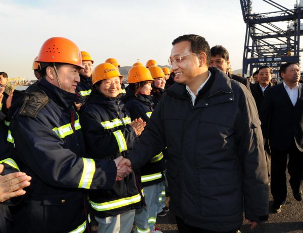 Chinese Vice Premier Li Keqiang (R, front) shakes hands with staff members of PDA Corporation at the Dayaowan Bonded Harbor Area in Dalian, northeast China's Liaoning Province, April 14, 2010. Li made an inspection tour in Liaoning from April 14 to 17. [Li Tao/Xinhua]