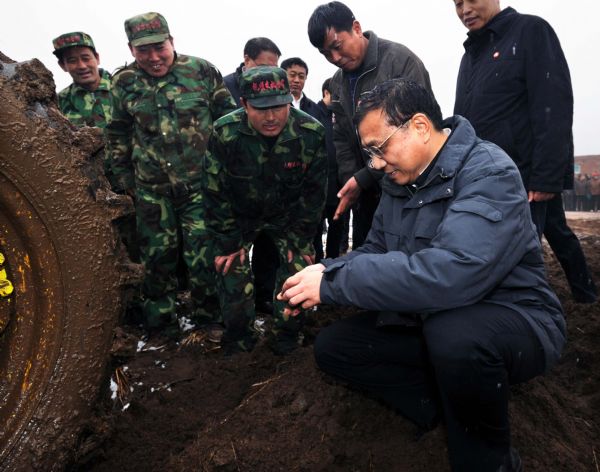 Chinese Vice Premier Li Keqiang (R, front) inspects the preparation work for ploughing and sowing in Qiujia Village, Fushun, northeast China's Liaoning Province, April 16, 2010. Li made an inspection tour in Liaoning from April 14 to 17. [Li Tao/Xinhua]