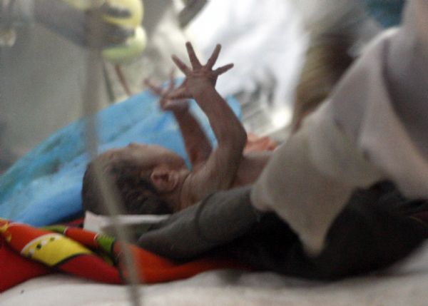 A newborn baby is seen at a makeshift shelter in Gyegu Town, Yushu County, northwest China's Qinghai Province, on April 17, 2010. [Shen Bohan/Xinhua]