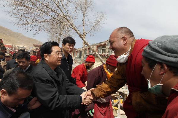 Chinese President Hu Jintao (L) consoles people in Yushu County of northwest China's Qinghai Province, April 18, 2010. President Hu arrived in quake-hit Yushu Sunday morning to direct relief work. [Xinhua]