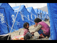 Children play near a tent in quake-hit area Yushu, Qinghai province, April 18, 2010. [Xinhua] 