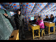 Students attend a class in a tent on the first school day since the April 14 earthquake in Yushu, Qinghai, April 18, 2010. [Xinhua] 