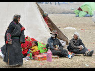 People affected by the quake rest near a tent in Yushu, Qinghai province, April 18, 2010. [Xinhua]