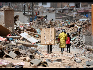 Local residents collect their belongs in the debris in Gyegu Town, the quake-hit Tibetan Autonomous Prefecture of Yushu, in northwest China's Qinghai Province, April 17, 2010. [Xinhua] 