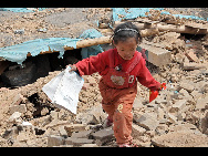 One of the daughters of Ngot (transliterated) finds a textbook from the debris in Gyegu Town of the Tibetan Autonomous Prefecture of Yushu, northwest China's Qinghai Province, April 17, 2010.[Xinhua] 