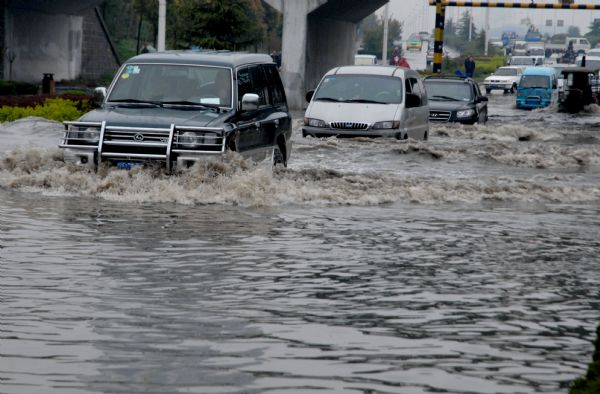 Vehicles brave their way through a flooded pass under a bridge after a sustaining rainfall since Saturday in downtown Huainan city, east China's Anhui Province, April 19, 2010.[Xinhua]