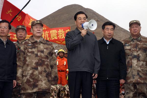 Chinese President Hu Jintao(C)speaks to soldiers of the Chinese People's Liberation Army and policemen carrying out relief work at Zhaxike Village of Gyegu Town in quake-hit Yushu County,northwest China's Qinghai Province, April 18, 2010.