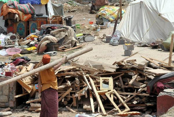 A local resident collects her belongs in Gyegu Town, the quake-hit Tibetan Autonomous Prefecture of Yushu, in northwest China's Qinghai Province, April 17, 2010. The 7.1-magnitude earthquake that struck Yushu of Qinghai Province, left 1,484 dead and 312 still missing, and about 100,000 people were relocated. 