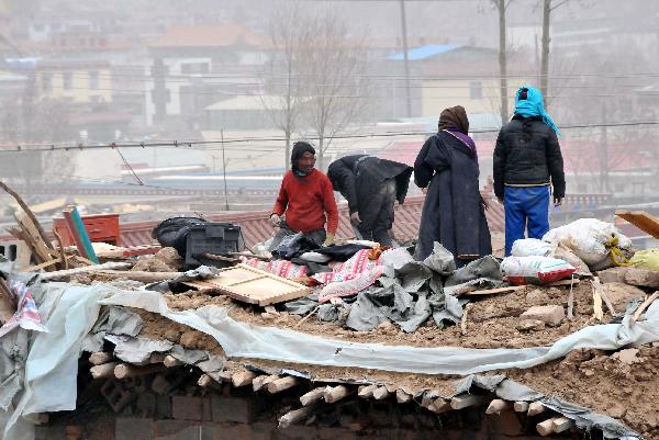 Local residents collect their belongs in the debris in Gyegu Town, the quake-hit Tibetan Autonomous Prefecture of Yushu, in northwest China's Qinghai Province, April 17, 2010.