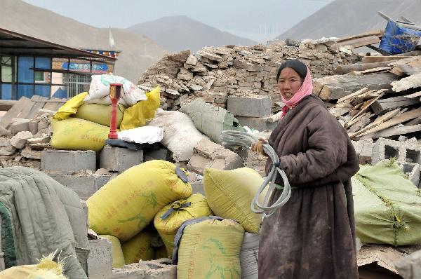 A woman collects her belongs in Gyegu Town, the quake-hit Tibetan Autonomous Prefecture of Yushu, in northwest China's Qinghai Province, April 17, 2010. 