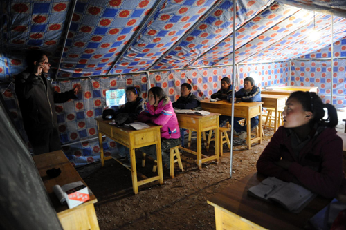 Students attend a class in a tent on the first school day since the April 14 earthquake in Yushu, Qinghai, April 18, 2010.